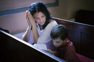 graphicstock beautiful woman with her son praying in the church HRMLd JAbb thumb