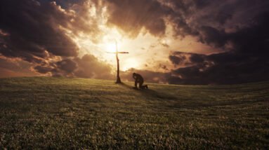 a man kneeling at a cross at sunset rXUS30WlR