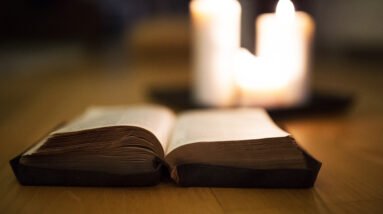 graphicstock close up of an old bible laid on wooden floor burning candles next to it H lYR3d8fW 2