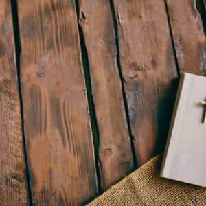 graphicstock image of christian book with cross on its cover on wooden background HBbfQtvsl