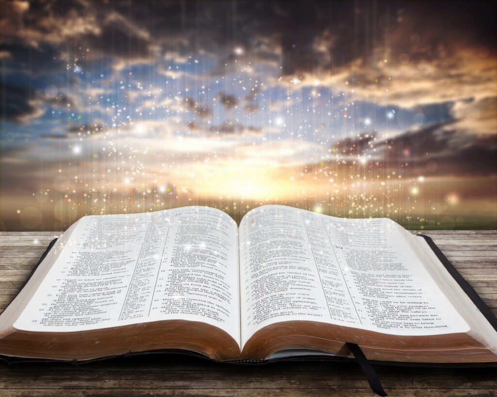 open glowing bible on table at sunset rmiNbyGxR