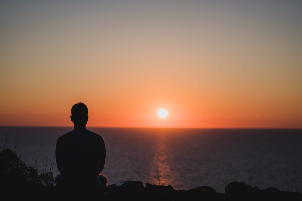 storyblocks young man looking to the sunset over sea enjoying and relaxing concept full of unforgettable experiences to recharge balance mind and body SuCIa8jXV