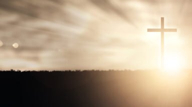 a christian cross at sunset with light flares rQSnCC gR