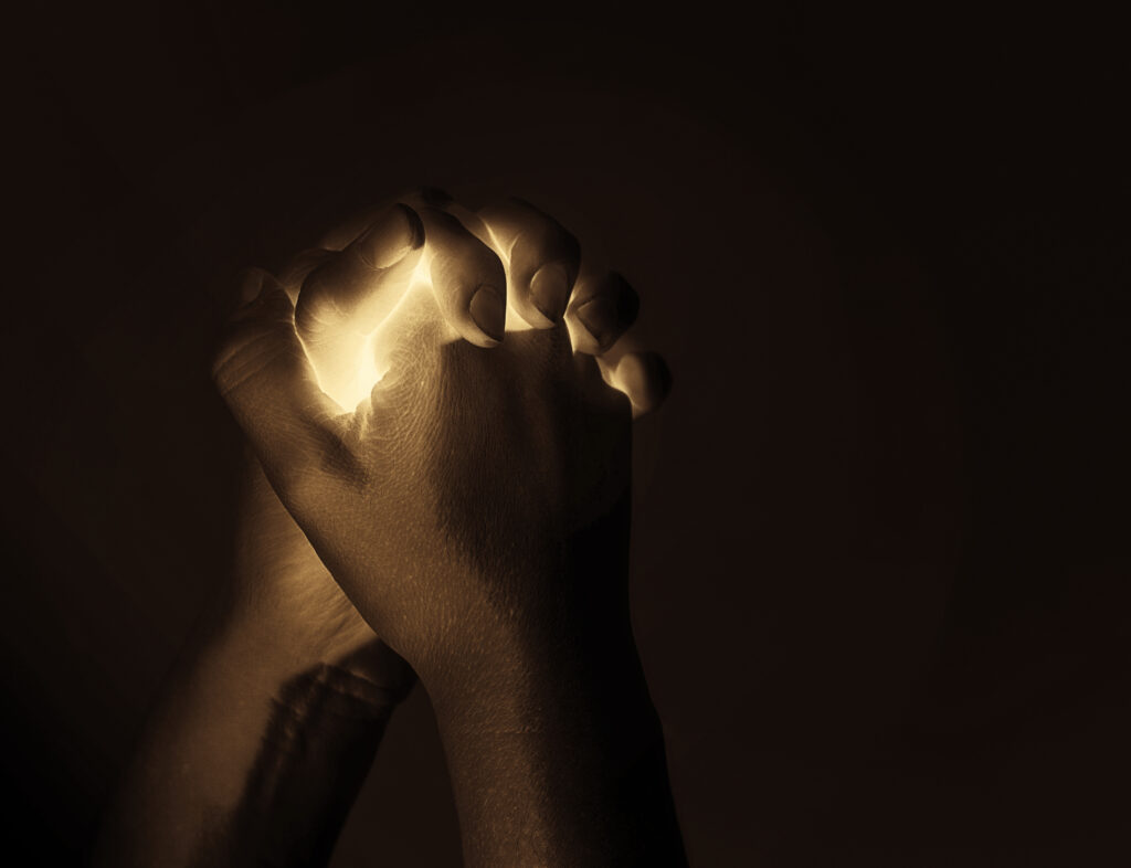abstract glowing lights inside two praying hands Bm ybkMe0