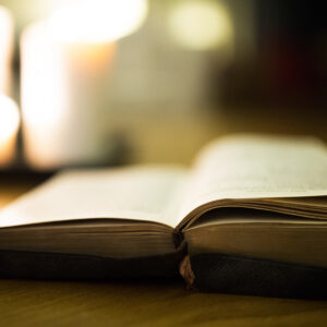 graphicstock close up of an old bible laid on wooden floor burning candles in the background H x53hu8Mb 2
