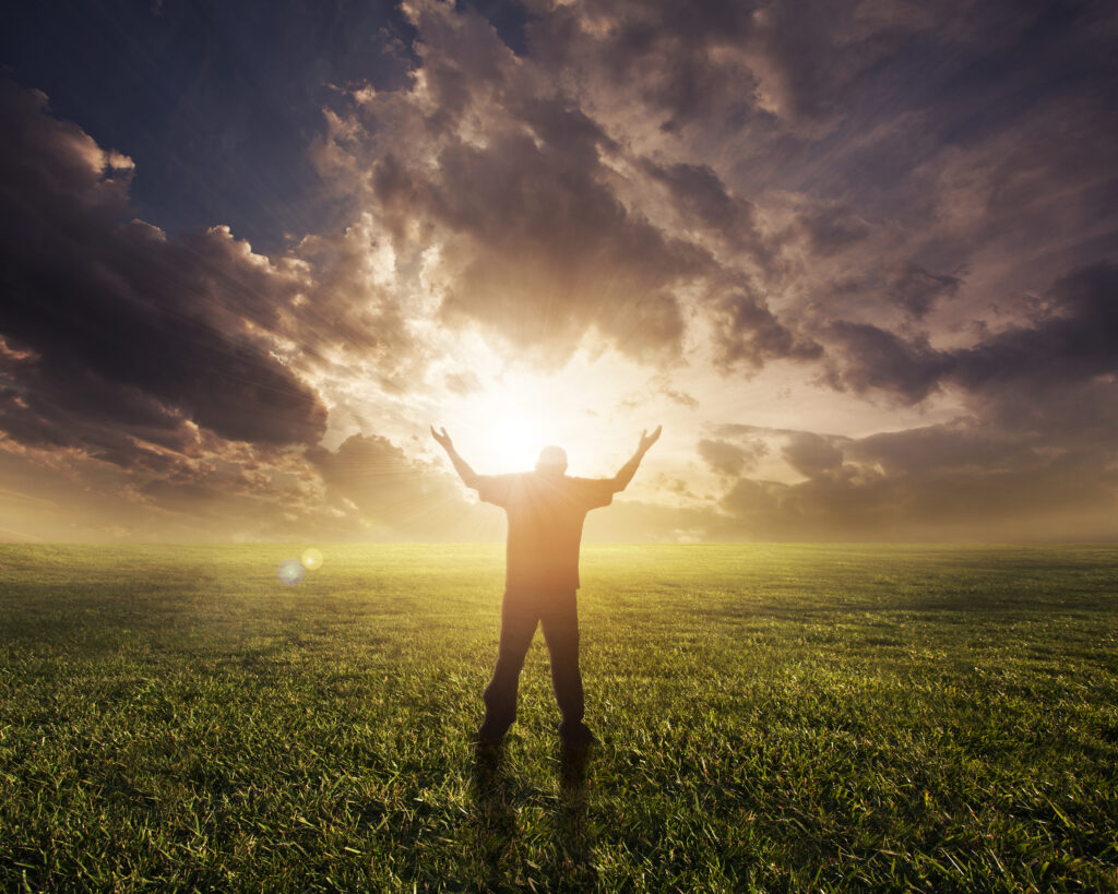 man lifting hands in worship at sunset HX6VZ1MxC