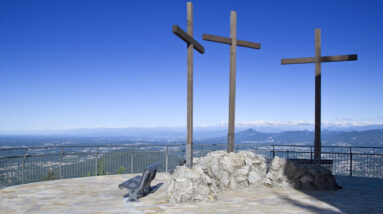 three wooden crosses on a viewing podium atop a mountain