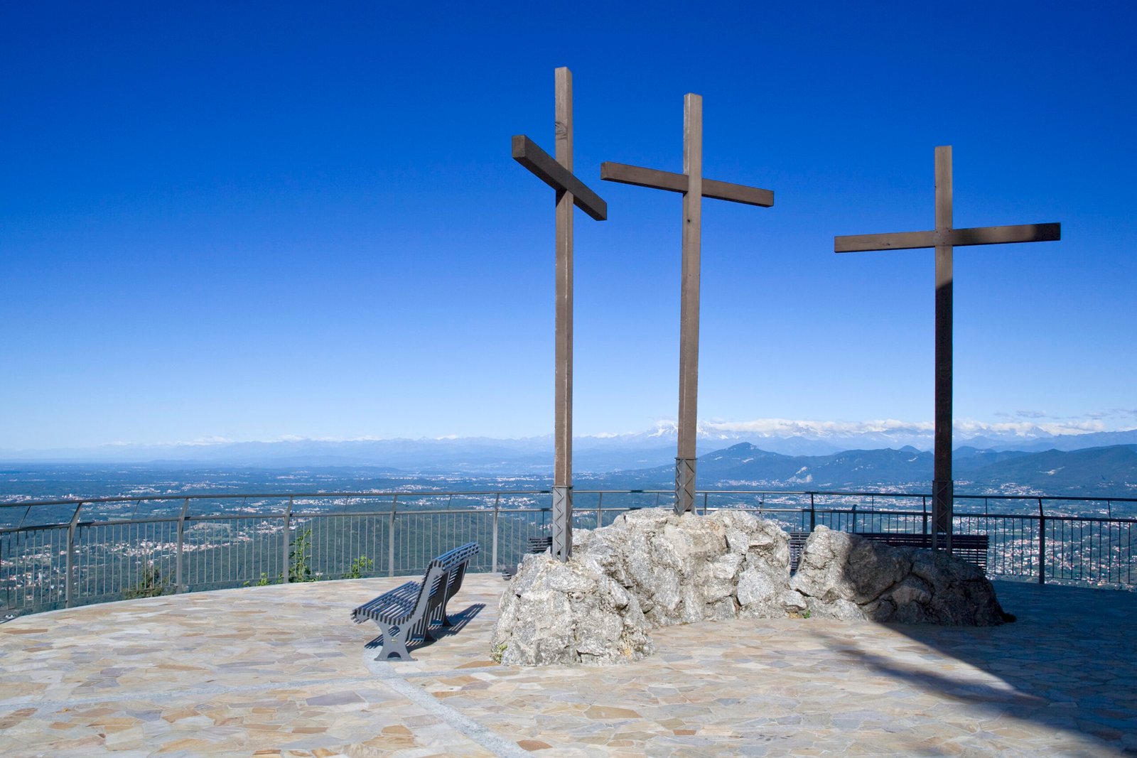 three wooden crosses on a viewing podium atop a mountain scaled