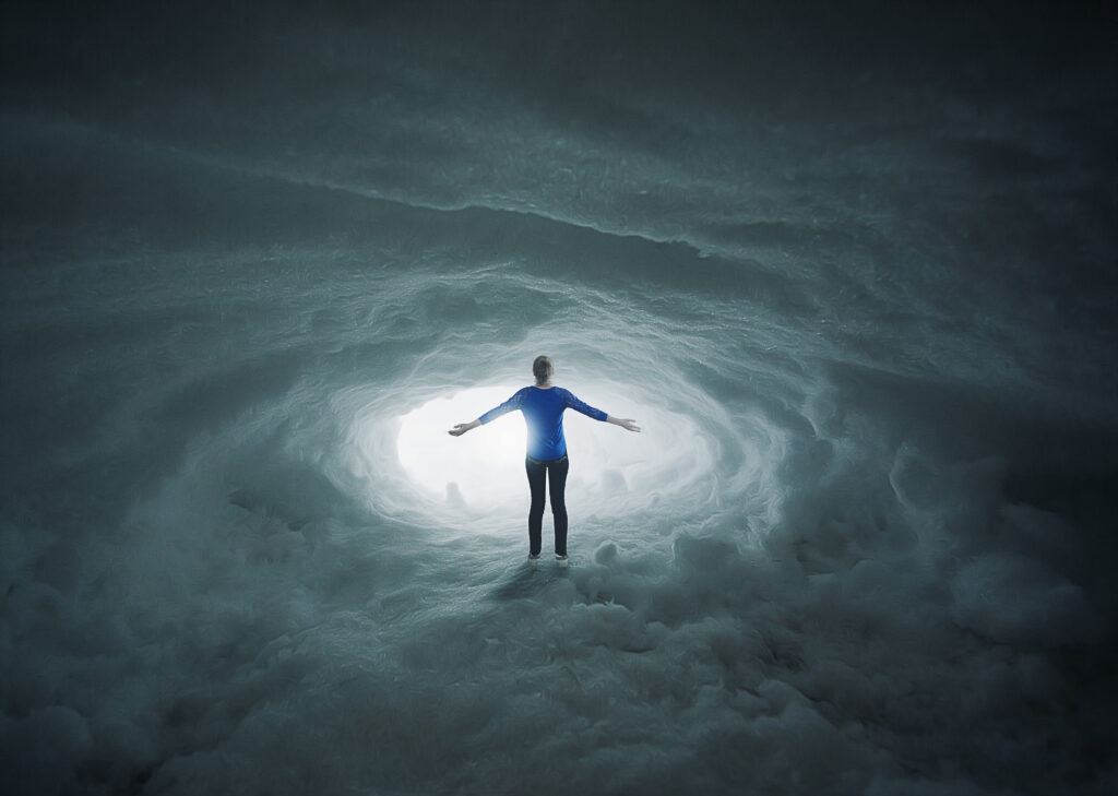 a woman lost in a snow cavern with her arms in praise B7bBxyMgR