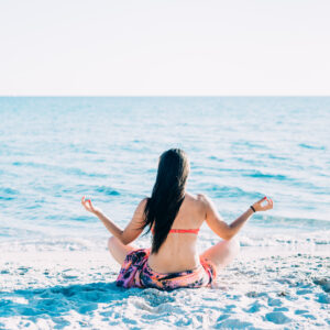 graphicstock back view of young beautiful woman doing yoga at the beach in summertime in lotus position relax meditation spiritually concept B6lwosmq1Z