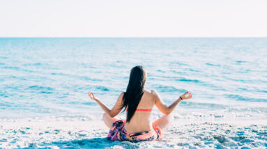 graphicstock back view of young beautiful woman doing yoga at the beach in summertime in lotus position relax meditation spiritually concept B6lwosmq1Z