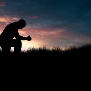 man praying in the grassy field HmgvG1fxR