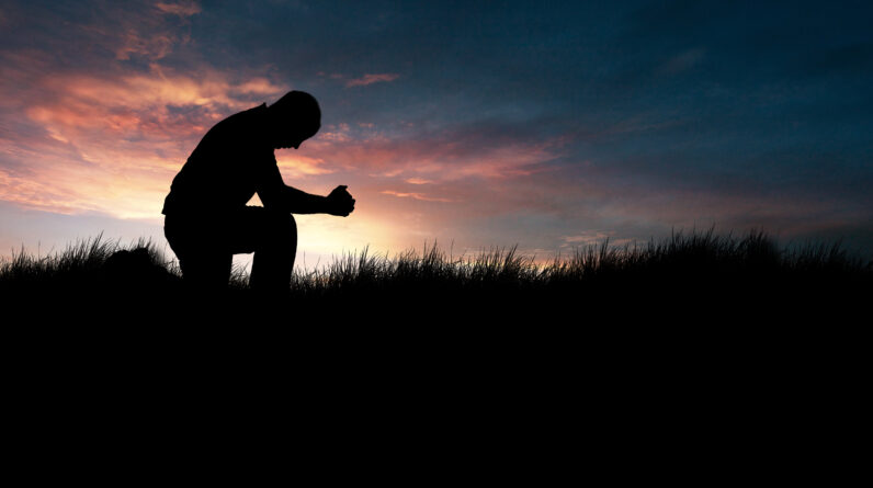 man praying in the grassy field HmgvG1fxR