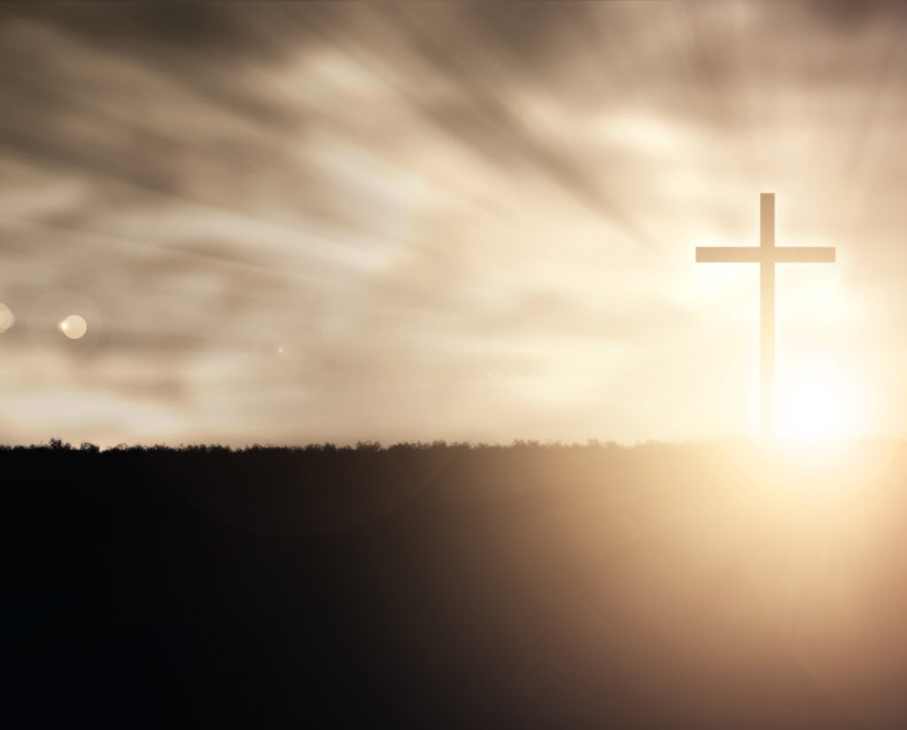 a christian cross at sunset with light flares rQSnCC gR