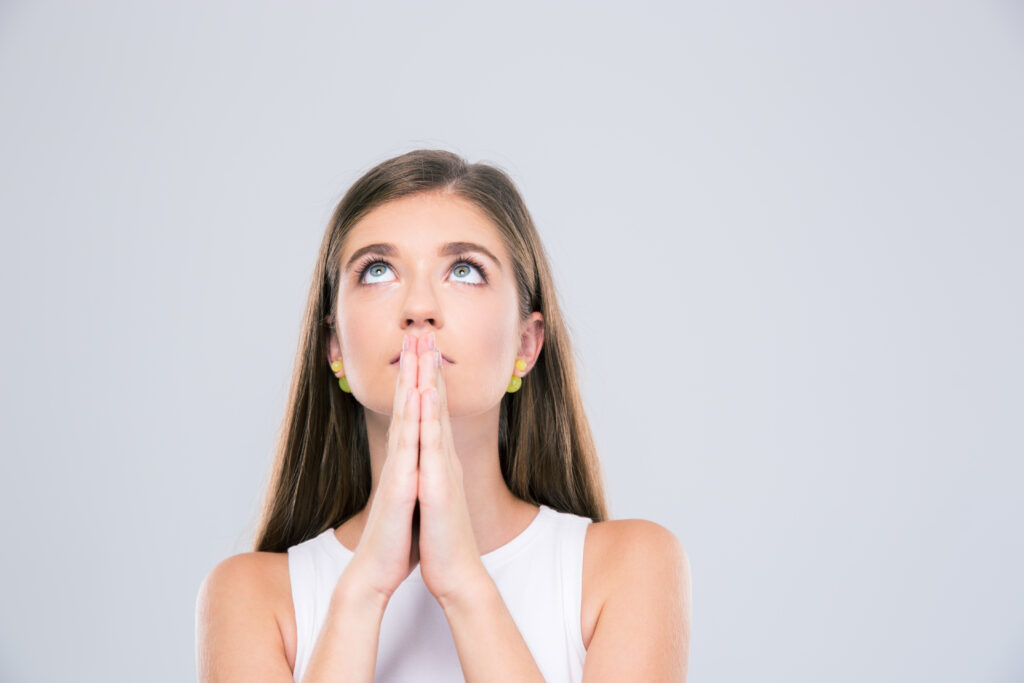 portrait of beautiful female teenager praying